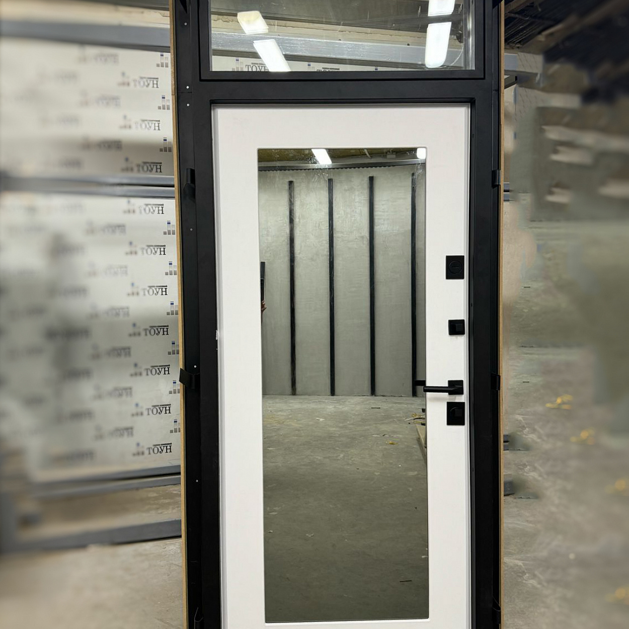 Металлическая дверь с верхней фрамугой, в которой есть окно